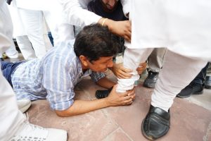 Delhi Minister Saurabh Bhardwaj holds feet of BJP MLA Vijendra Gupta on Saturday