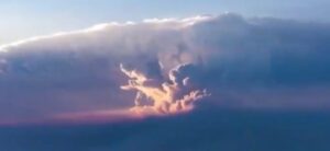 A pyrocumulonimbus cloud towers above a wildfire, its dark column of smoke billowing into the upper atmosphere — an increasingly common sight as global heating intensifies fire seasons worldwide.