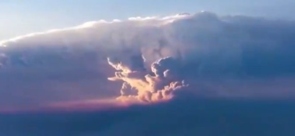 A pyrocumulonimbus cloud towers above a wildfire, its dark column of smoke billowing into the upper atmosphere — an increasingly common sight as global heating intensifies fire seasons worldwide.