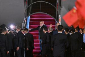 Russian President Vladimir Putin departs after concluding his visit to China, walking near the aircraft staircase with officials and security personnel visible at the departure area.