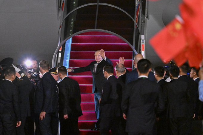 Russian President Vladimir Putin departs after concluding his visit to China, walking near the aircraft staircase with officials and security personnel visible at the departure area.