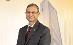 RBI Governor Sanjay Malhotra announcing the Monetary Policy Committee decision with graphics showing repo rate, inflation, fiscal deficit and crude oil prices.