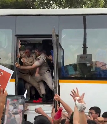 Protestors escape from the bus even while Delhi police wrestle with them.